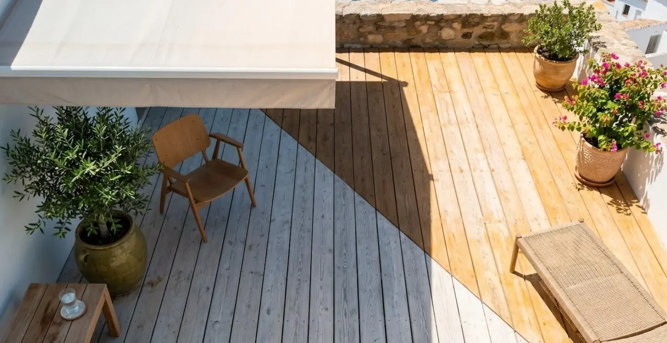 Vista cenital de terraza dividida en dos zonas: lado izquierdo con sombra fresca de toldo mostrando madera clara y planta verde, lado derecho bajo sol intenso con colores cálidos saturados y superficie brillante